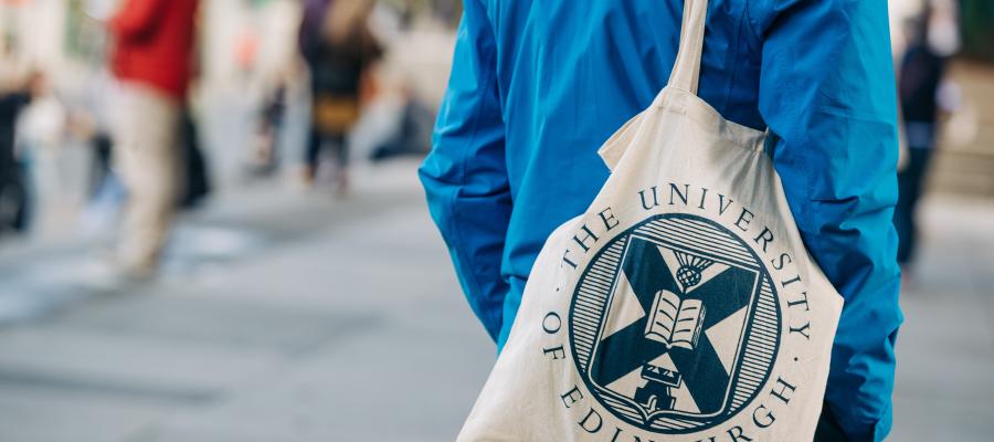Colour photo of a person wearing a University of Edinburgh branded bag over their shoulder