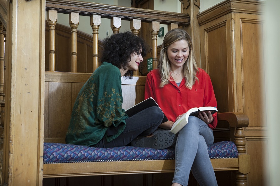 Colour photos of students sitting, smiling, and reading together in New College