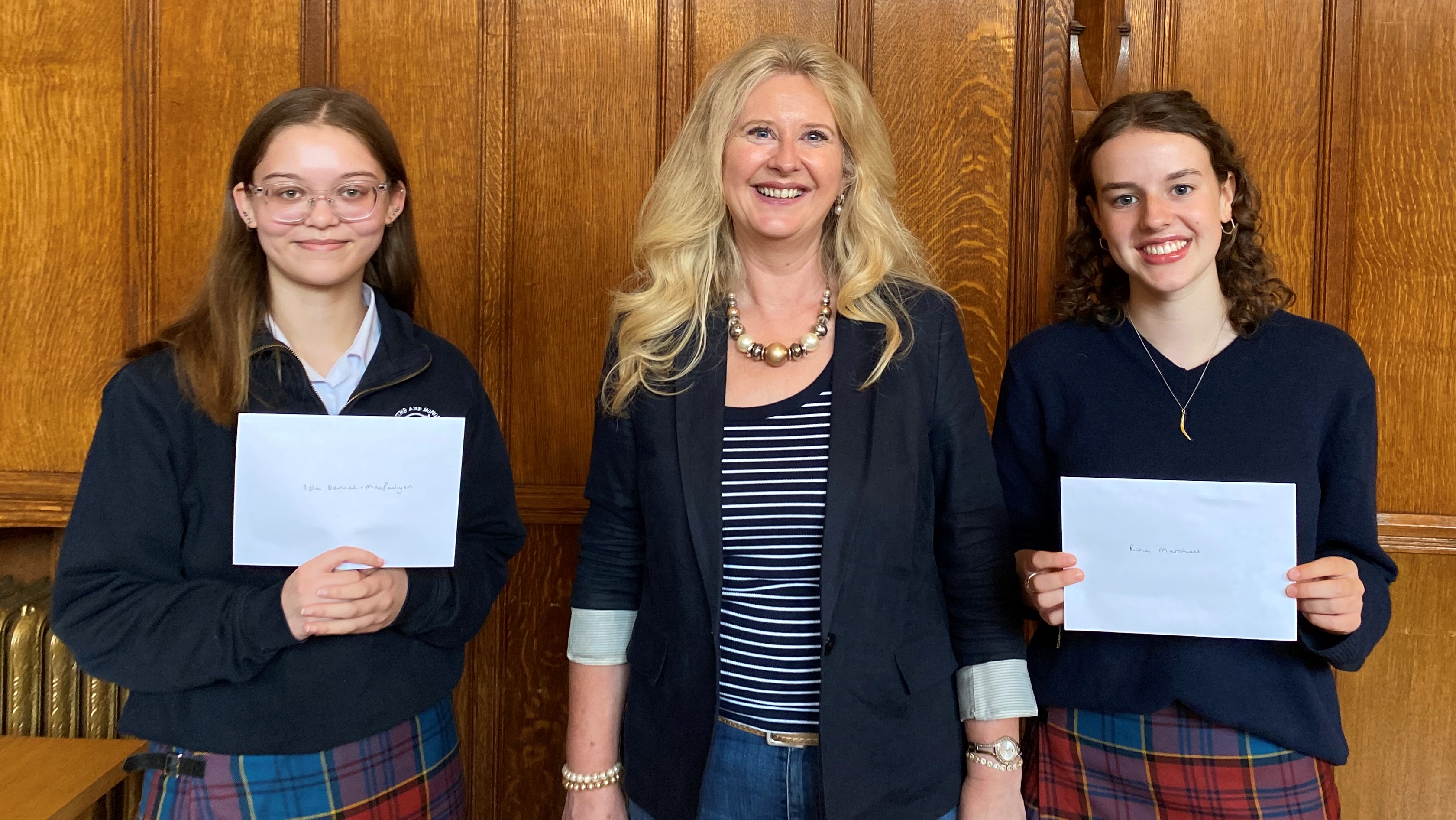 Colour photo of School of Divinity Video Competition winners stood holding their prizes with Professor Helen Bond